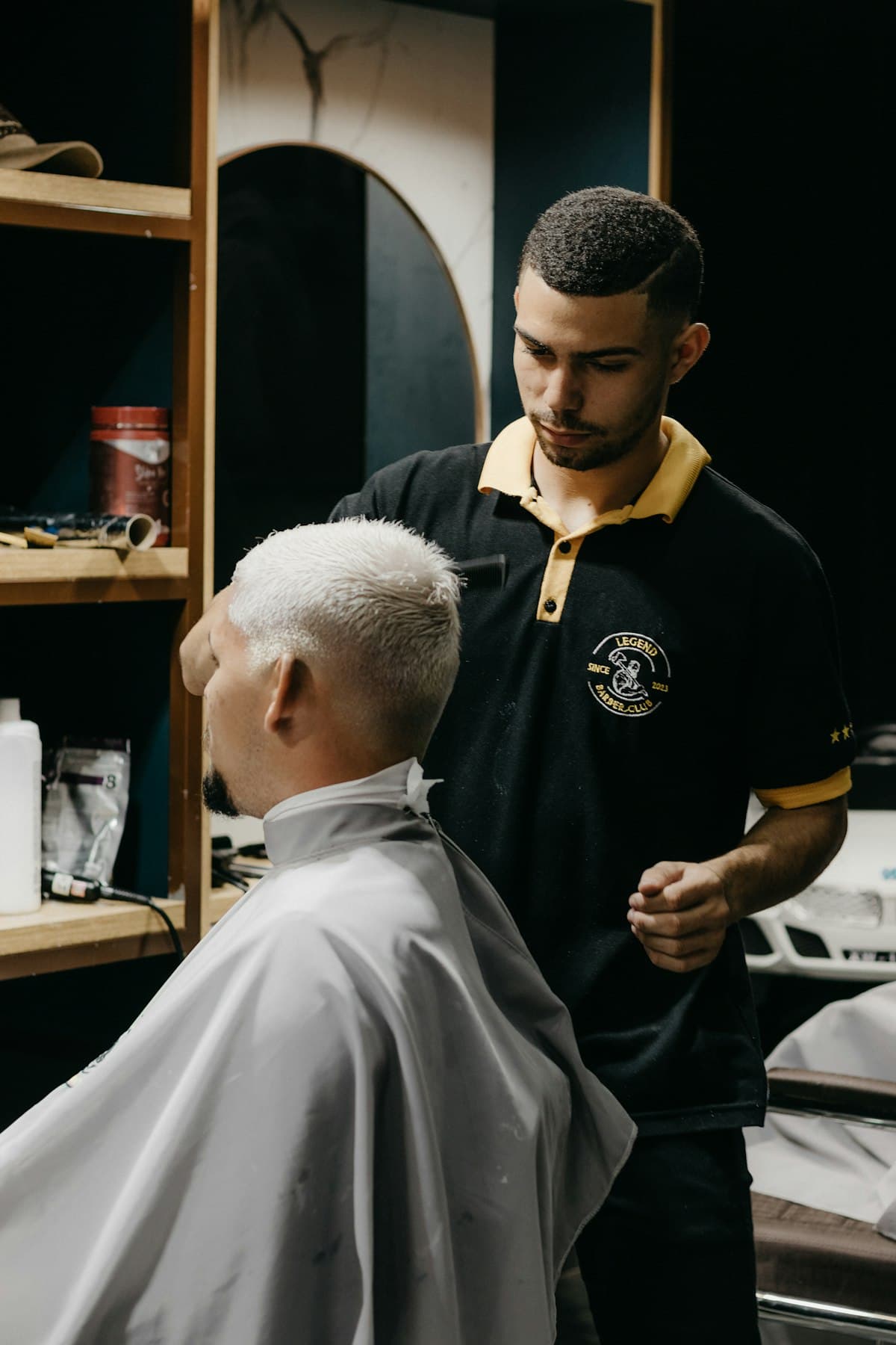 Barbeiro conversando com o cliente durante o corte