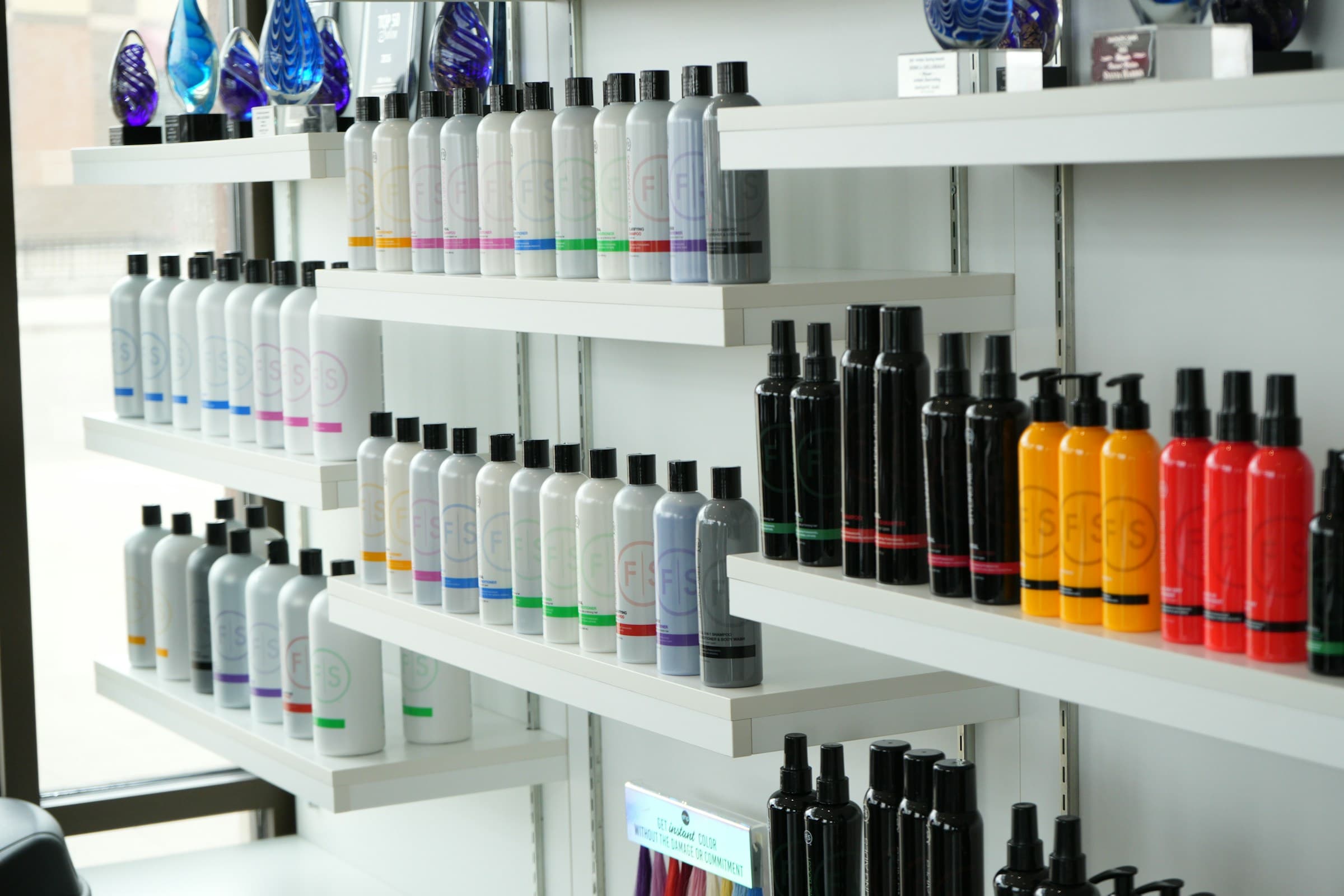 Prateleiras de salão com fileiras de frascos de produtos para cabelo