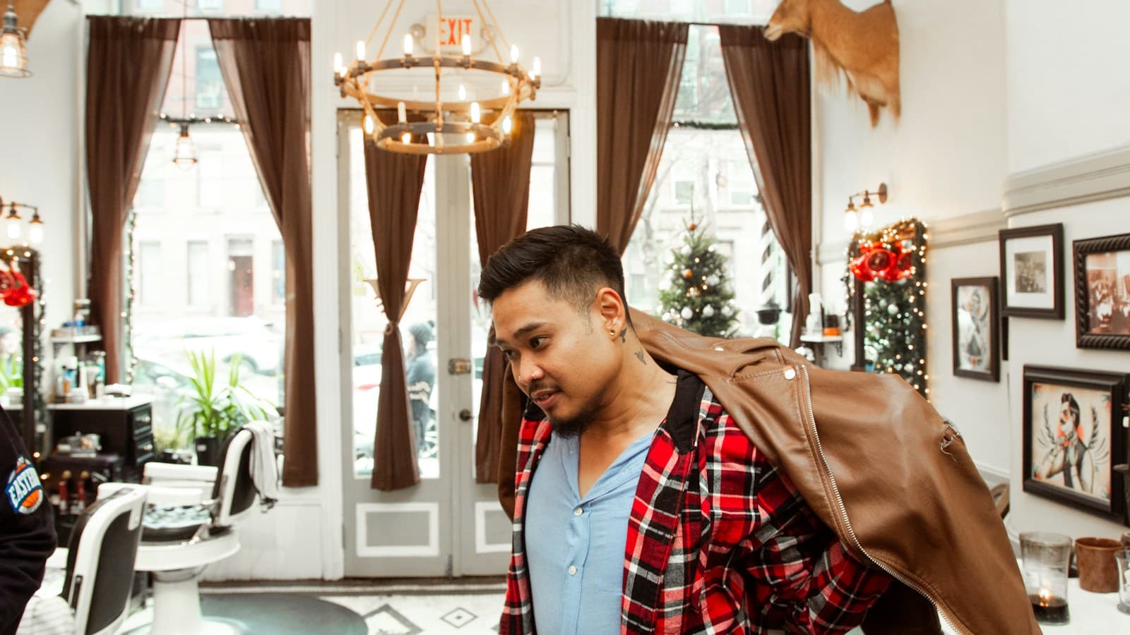 Cliente veste a jaqueta para sair da barbearia depois do atendimento