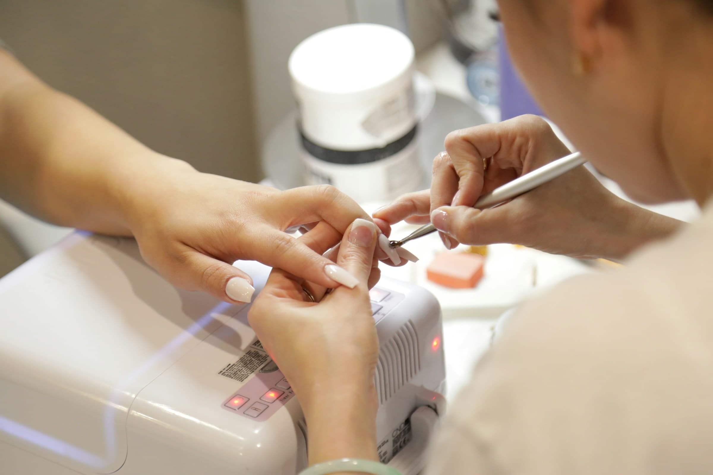 Cliente faz as unhas com a manicure no salão