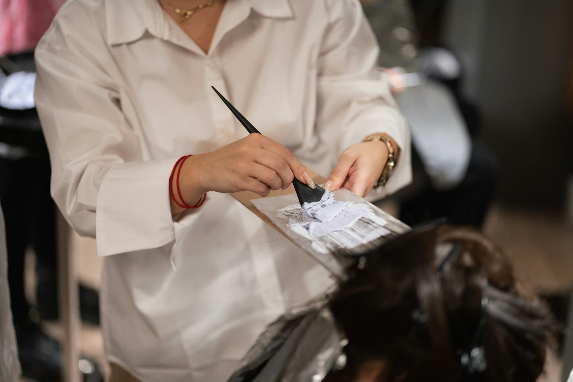 Cabeleireira corta o cabelo de uma cliente no salão