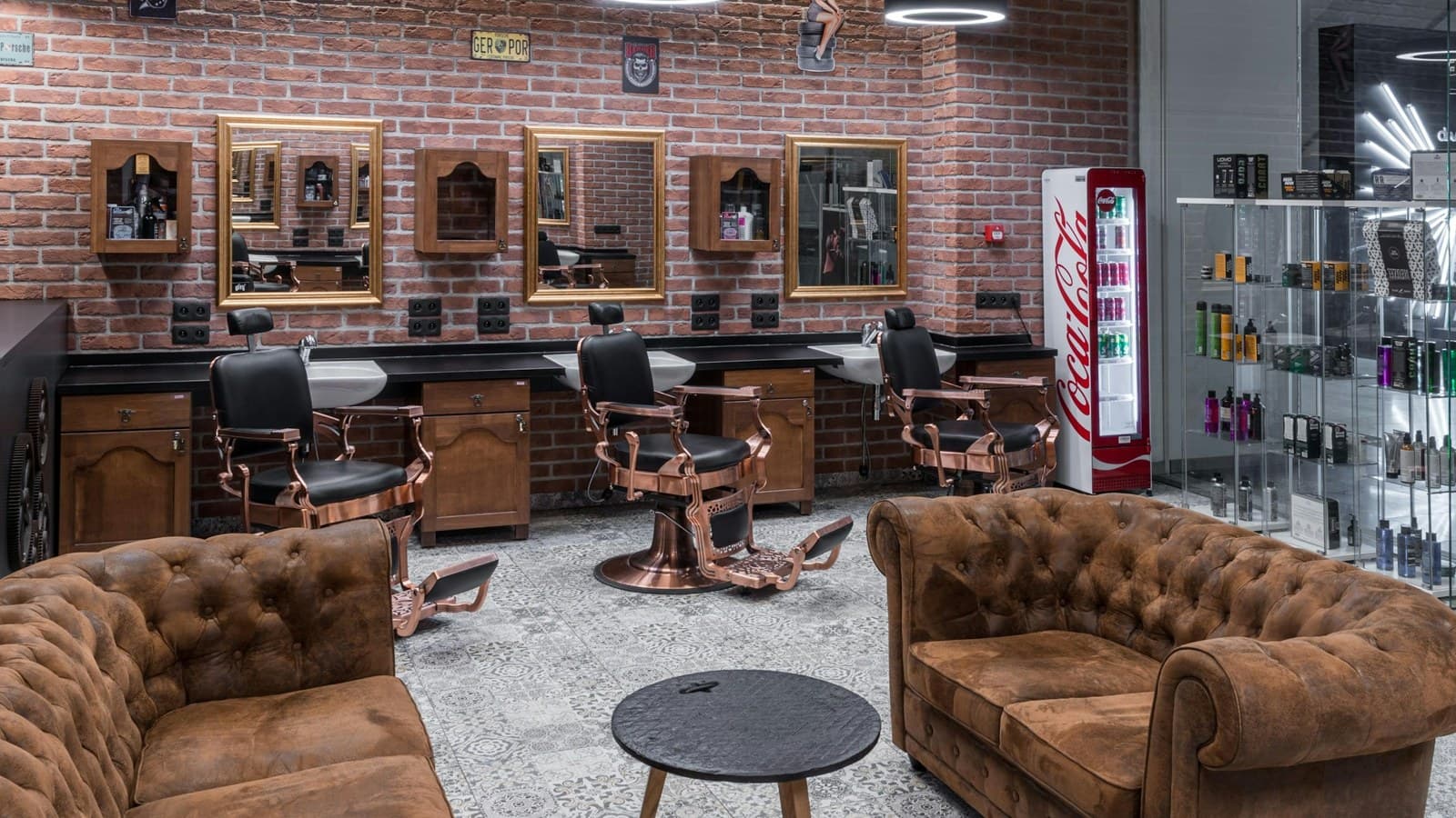 Sofás de espera na frente das cadeiras de uma barbearia de parede de tijolos
