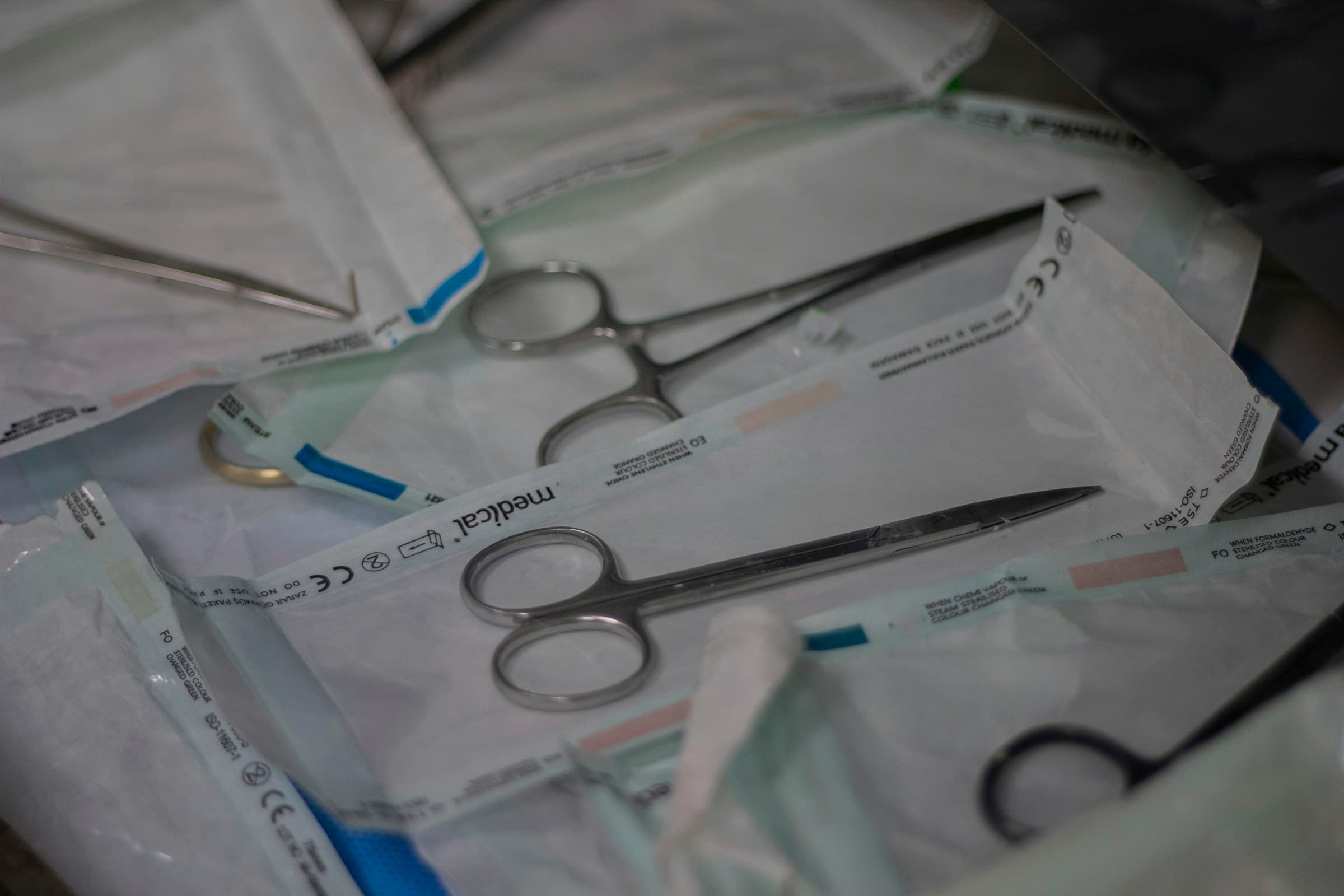 Tesouras e pinças de aço lacradas em envelopes de esterilização